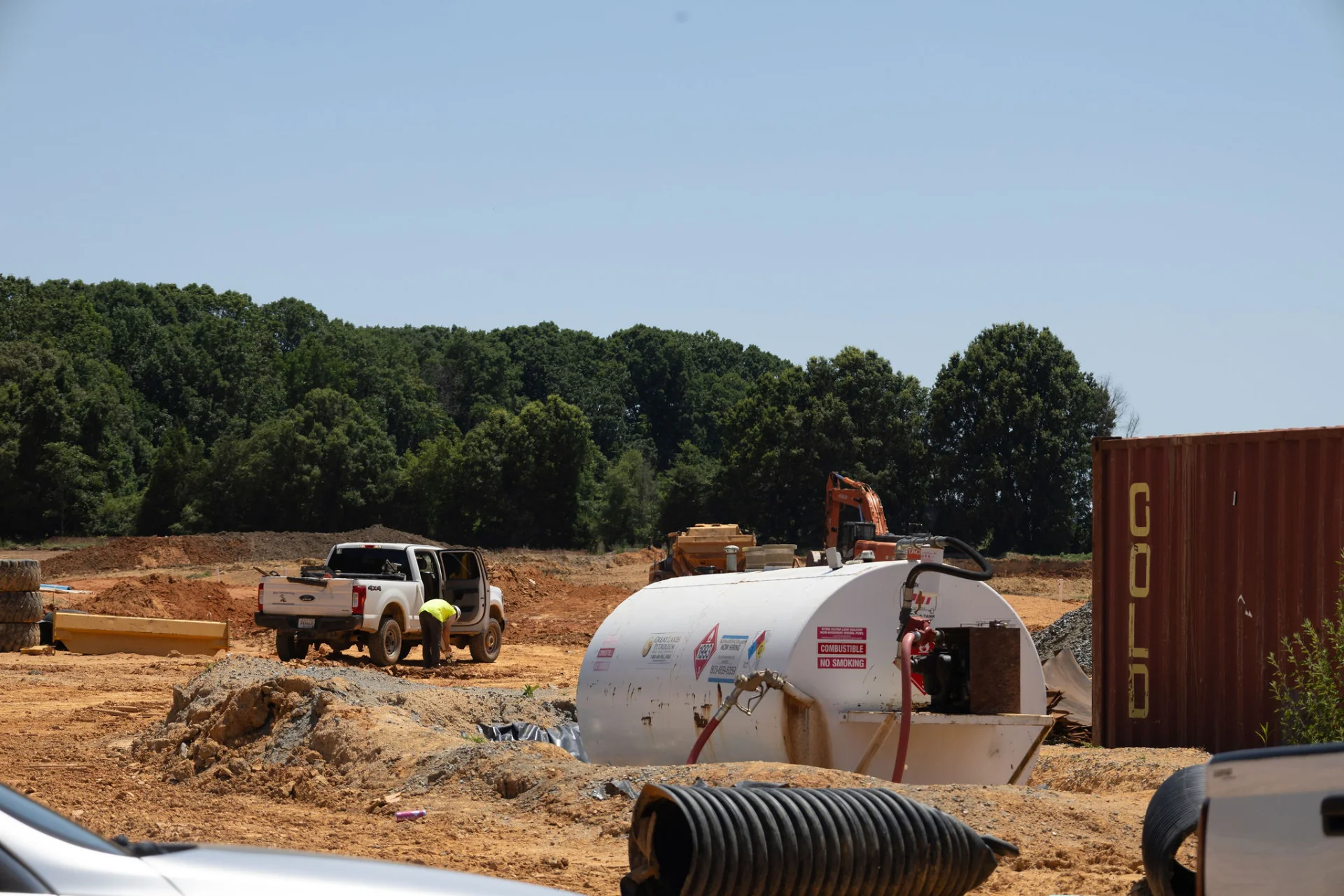 Construction site with heavy machinery and equipment on a dirt field.